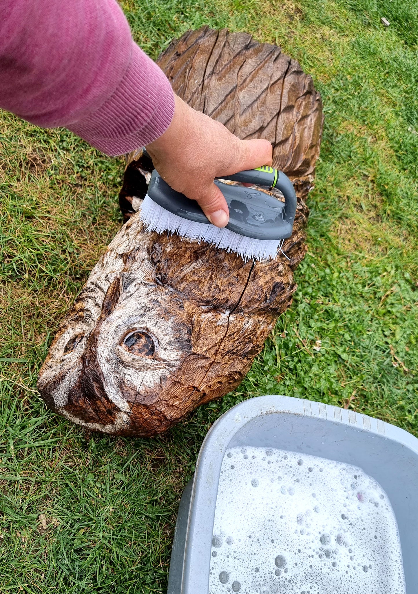 Scrubbing a sculpture with warm soapy water